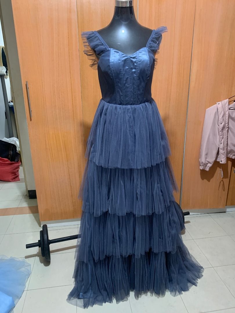Dusty Blue Tiered Tulle Gown (Category: Evening dresses & gowns) located in Quezon City. Submitted by rafasamirgal (Listing ID 1407368485, Image 1). Description: - Elegant dusty blue gown - Floor-length design - Fitted bodice - Delicate ruffle strap details - Tiered tulle skirt - Back zipper closure - Perfect for formal events and special occasions.