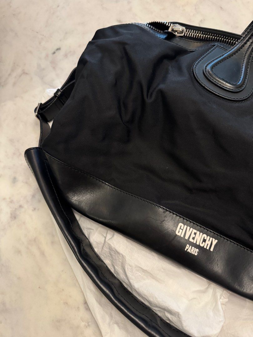 Givenchy Black Nylon Handbag (Category: Luxury Bags & Wallets) located in Taguig. Submitted by sourcedbym (Listing ID 1407266263, Image 3). Description: - Authentic Givenchy handbag - Black nylon body with leather accents - Top zipper closure - Dual top handles - Detachable shoulder strap - Givenchy logo on front - Branded metal plate inside No dustbug. Generic one included #Givenchy #traveltote.