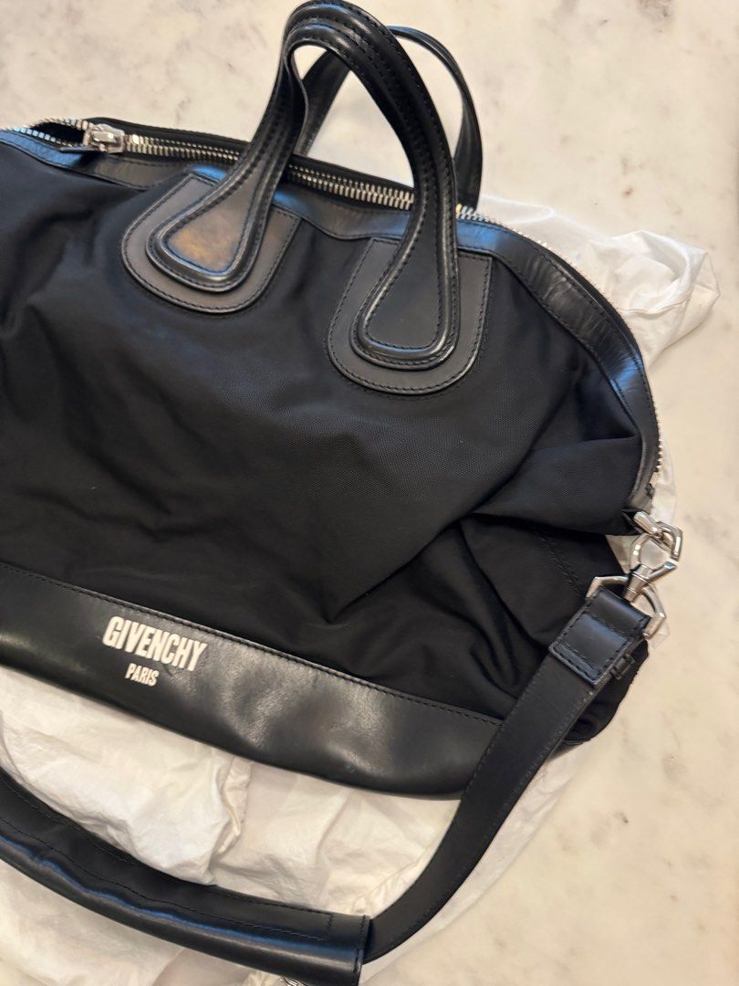 Givenchy Black Nylon Handbag (Category: Luxury Bags & Wallets) located in Taguig. Submitted by sourcedbym (Listing ID 1407266263, Image 2). Description: - Authentic Givenchy handbag - Black nylon body with leather accents - Top zipper closure - Dual top handles - Detachable shoulder strap - Givenchy logo on front - Branded metal plate inside No dustbug. Generic one included #Givenchy #traveltote.
