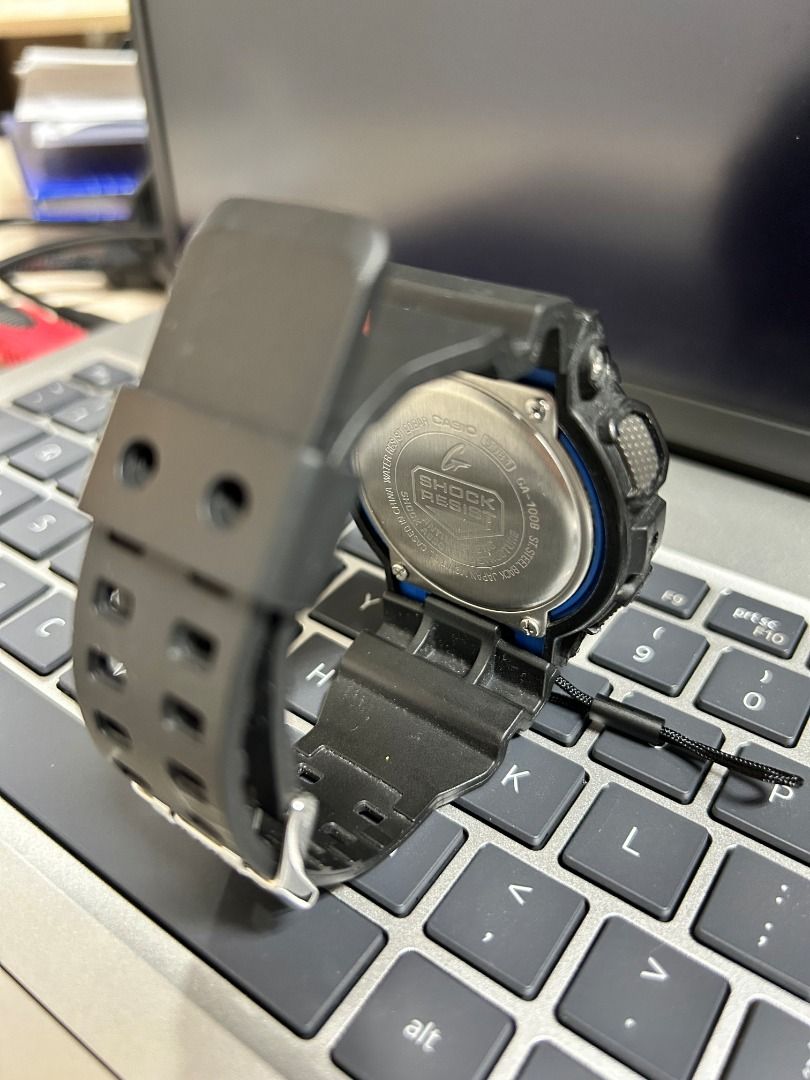 G-Shock GA-100 Watch (Category: Men's Watches) located in Cebu City. Submitted by ehdstuff (Listing ID 1407374845, Image 3). Description: - Black G-Shock GA-100 watch - Digital display with day and date - Red and blue accents - Casio and G-Shock branding on the back - Black strap and buckle.
