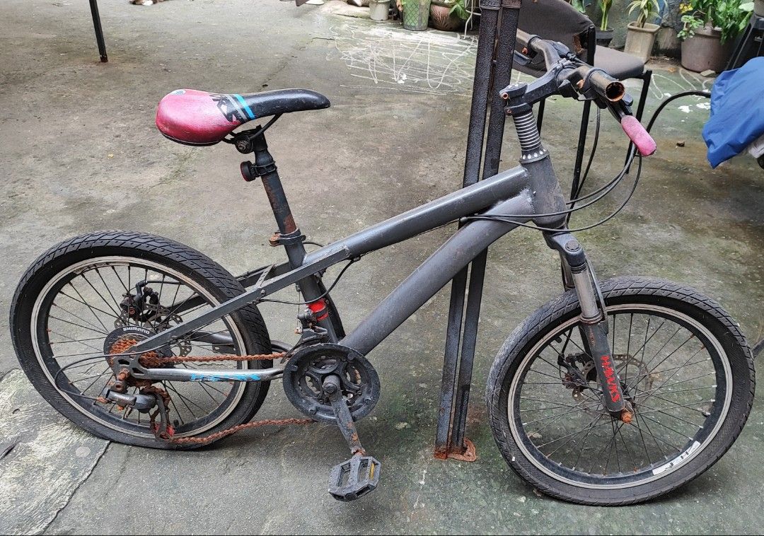 Kiddie Mountain Bike (Category: Bicycles) located in Taguig. Submitted by smartoption (Listing ID 1407217570, Image 1). Description: S aglit lang nagamit at kinalawang na ang ibang mga parts habang naka stock. kayo na bahala mag lubricate. - Mountain bike with disc brakes and suspension fork - Stylish gray frame - Eye-catching pink and black seat - Handlebars with shifters - Chain shows some rust.