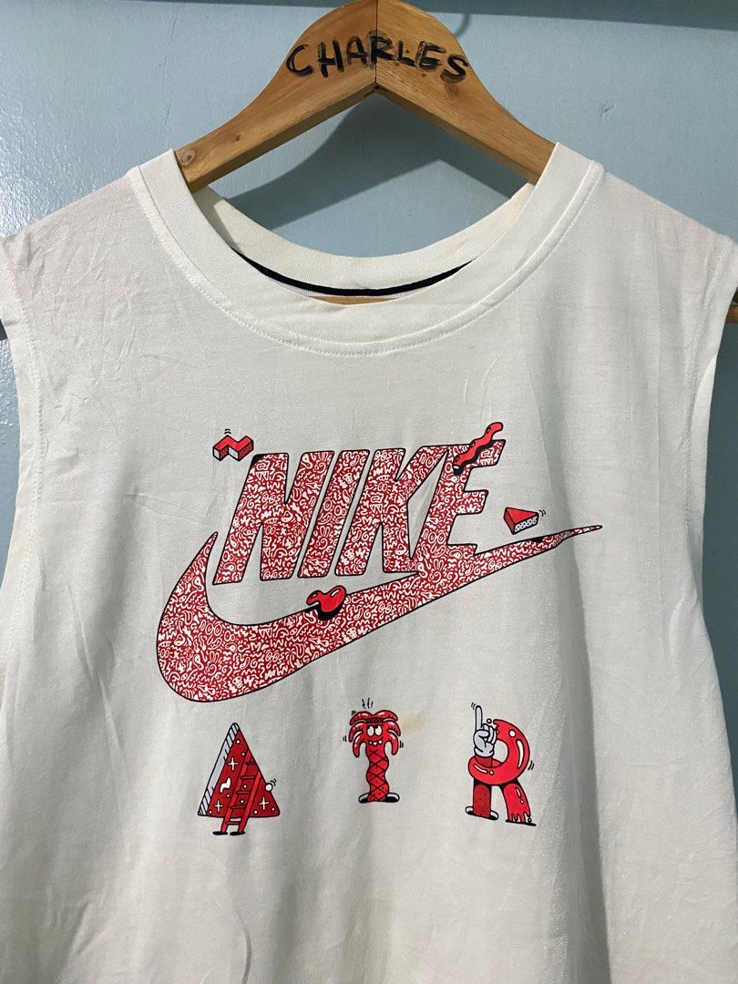 Nike Air Graphic Tank Top - White (Category: Sleeveless) located in Cabanatuan. Submitted by chingweyyy (Listing ID 1407306520, Image 2). Description: - White Nike tank top - Unique graphic design - Features Nike logo and "AIR" in playful font - Sleeveless with round neckline - Size: M - Made in China - Style: SU161203NIG - Code: 728468-100.