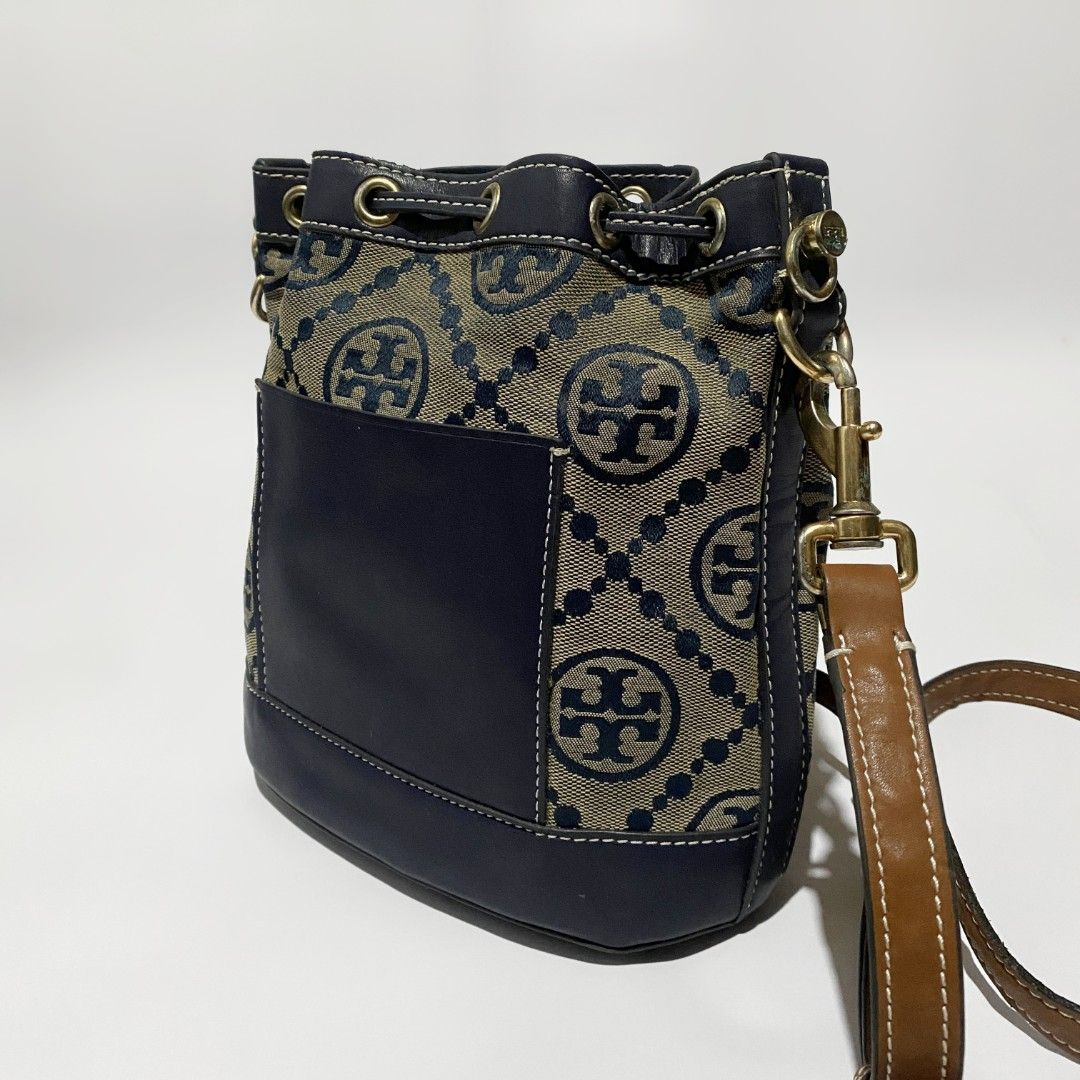 Tory Burch T Monogram Bucket Bag (Category: Luxury Bags & Wallets) located in Bacolod City. Submitted by bt_ph (Listing ID 1407272228, Image 3). Description: - Tory Burch bucket bag - Dimensions: 9. 5 x 8.5 x 5 inches - Shoulder drop: 22 - 30 inches - 1 outer card pocket - 1 inner pocket - Pen writing stain - signs of usage - Signature T Monogram design - Navy blue leather base and trim - Gold-tone hardware - Drawstring closure - Detachable shoul
