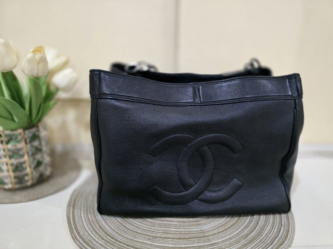 Authentic Chanel Black Leather Tote Bag (Category: Luxury Bags & Wallets) located in Davao. Submitted by bella0613 (Listing ID 1408932544, Image 2). Description: - Authentic Chanel tote bag - Black leather - Chain straps - Iconic Chanel logo embossed on front - Structured shape with flat base - Protective metal feet - Interior branded label: "CHANEL MADE IN ITALY" - Holo intact - Authenticated.
