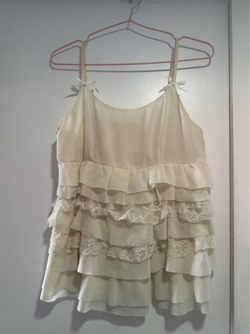 ivory/cream tiered ruffle top (Category: Sleeveless) located in Quezon City. Submitted by pur6ing (Listing ID 1408959727, Image 1). Description: - FITS S-L - thrifted this/no brand - lace detail, tiered hems - side zippers (see 2nd pic) - bow detail on strap - a-line top very babygirl/coquette u alr know.