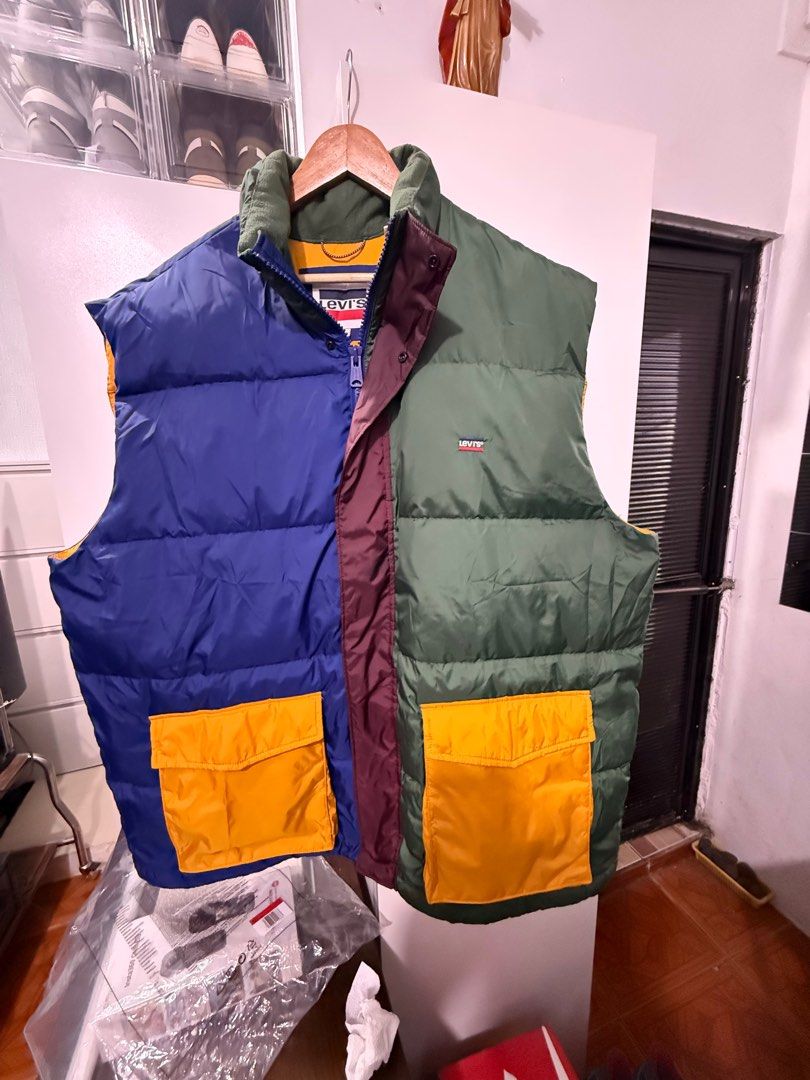 Levi's Colorblock Puffer Vest (Category: Vests) located in Manila. Submitted by blank_espacio (Listing ID 1408988913, Image 1). Description: - Levi's puffer vest - Unique colorblock design: blue, green, and maroon panels - Two front pockets with yellow lining - Zip-up closure - Solid blue back - Collar - Levi's logo patch.