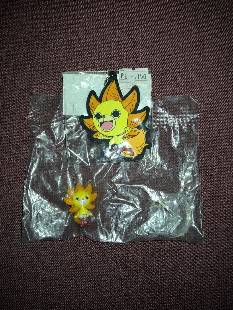 One Piece Thousand Sunny Keychain and Figure set (Category: Character Goods) located in Pasig City. Submitted by hazelscollectibles (Listing ID 1408977339, Image 1). Description: - Two One Piece Thousand Sunny items for sale! - Item 1: Keychain - Item 2: Small figure with stand - Both items are brand new and still in their original packaging. - Keychain features a black backing with the Bandai logo..