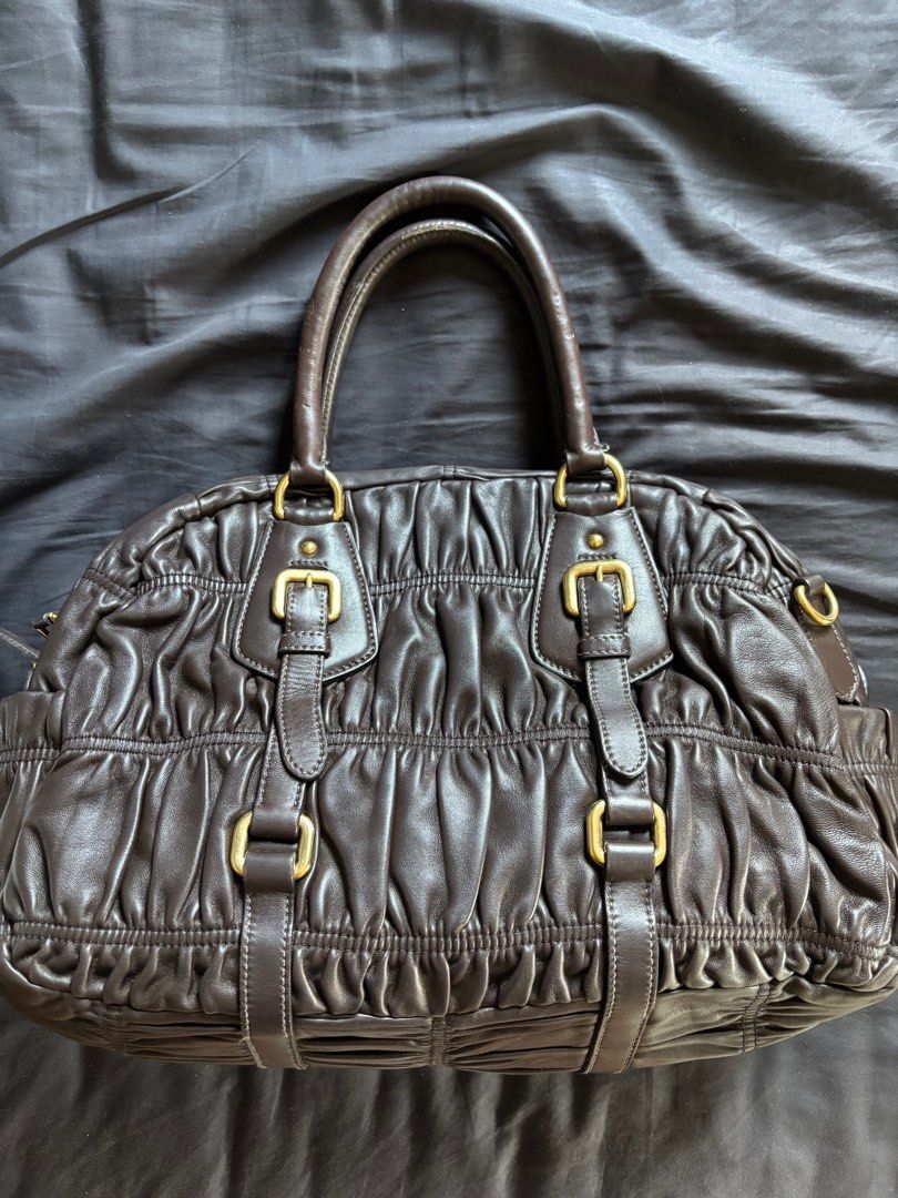 Prada Nappa Gaufre (Category: Luxury Bags & Wallets) located in Los Banos. Submitted by declutterlistt (Listing ID 1408898926, Image 2). Description: Selling my mom’s old bag. - Authentic - Brown leather - Ruched design - Gold-tone hardware - Top handle - Detachable shoulder strap - Includes dust bag and authenticity card - Prada logo lining and zippered pocket inside Seller is based in Laguna and meetups will be on January 2 to January 3 in MOA.