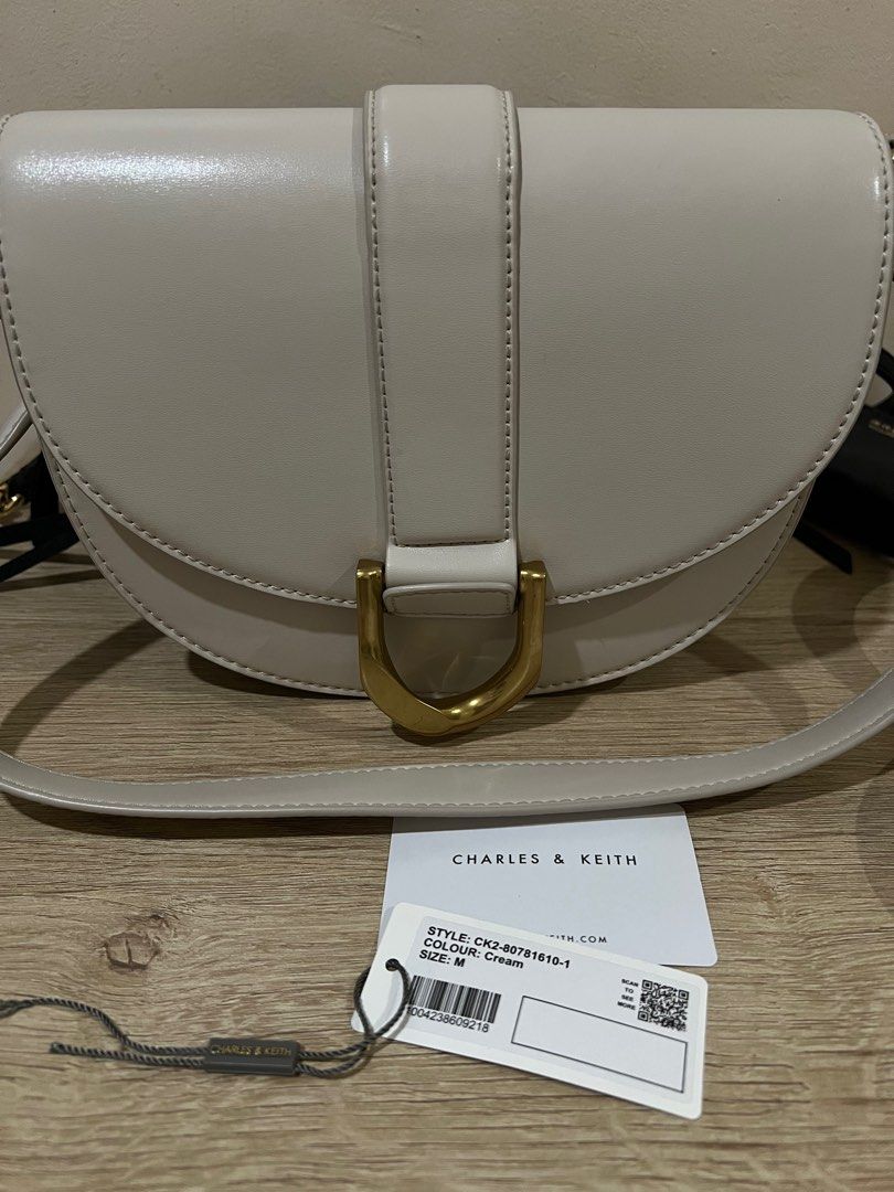 Charles & Keith Saddle Bag (Category: Luxury Bags & Wallets) located in Rizal. Submitted by thedailypouch (Listing ID 1409172923, Image 2). Description: Rfs: decluttering - Charles & Keith saddle bag -original 💯 - Color: Crown - Stylish curved design - Gold-tone buckle - Detachable shoulder strap - Style number: CK2-80781610-1 - Interior: Zippered pocket - Branded with Charles & Keith logo.