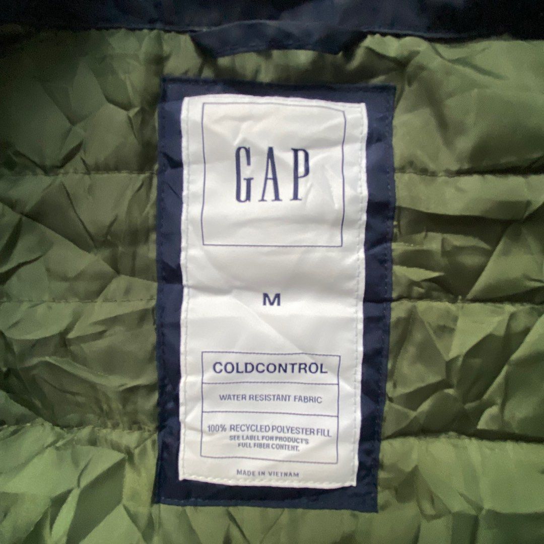 GAP Coldcontrol Vest - Navy Blue (Category: Vests) located in Manila. Submitted by justforthriftingpmpg (Listing ID 1409078351, Image 3). Description: - Navy blue GAP Coldcontrol vest - Dimes: 21x27 - Features: - Full zip closure - Two side pockets - Stand-up collar - Interior lining: Olive green - Water-resistant fabric - 100% recycled polyester fill - Made in Vietnam.