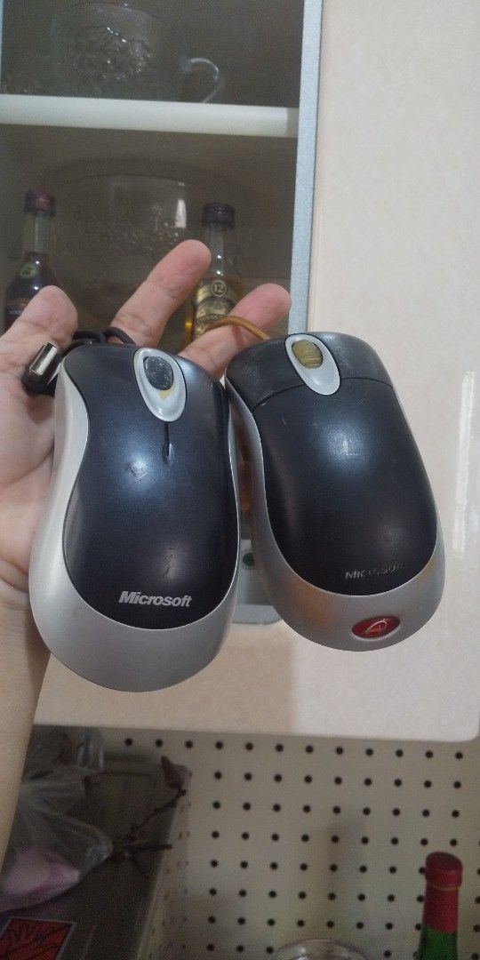 Microsoft Comfort Optical Mouse Package (as-is) (Category: Mouse & Mousepads) located in Carmona. Submitted by rpute (Listing ID 1409071943, Image 2). Description: Two Microsoft Comfort Optical Mouse 1000. One mouse has a black body with a silver trim, and the other has a red body. Both have a scroll wheel and a USB connection. The black mouse has a black cable, while the red mouse has a yellow cable. Both mice are in working condition..