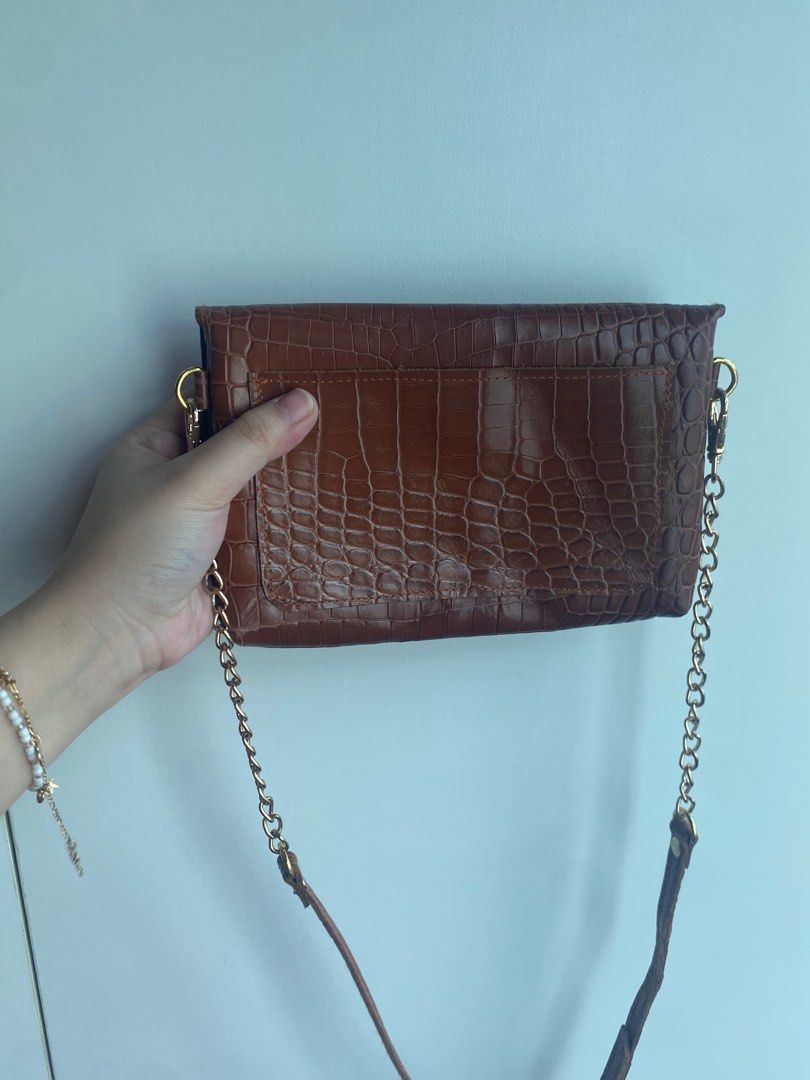 Brown Crocodile-Embossed Crossbody Bag with Chain Strap (Category: Cross-body Bags) located in Pasig City. Submitted by angelaaaj (Listing ID 1409315606, Image 2). Description: - Brown crocodile-embossed design (genuine leather) - Gold-tone chain strap - Flap closure with gold button - Made of leather - Single compartment - Stylish for everyday use.