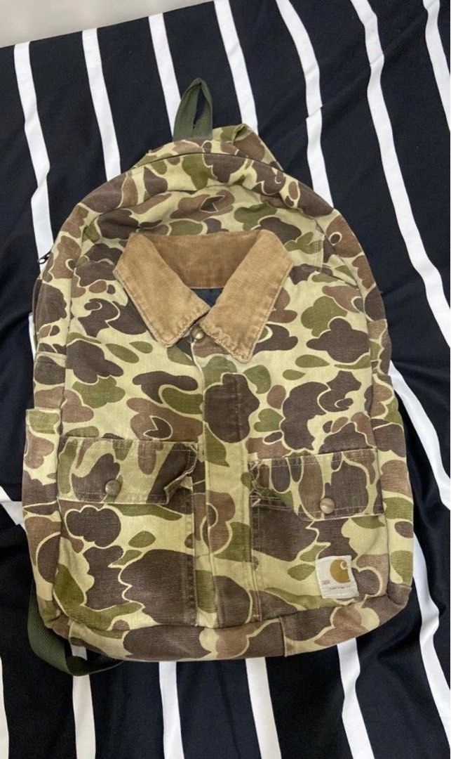 Carhartt Camo Backpack (Category: Backpacks) located in Naga. Submitted by mnmaxx (Listing ID 1409278892, Image 1). Description: Carhartt backpack with camo pattern. Features corduroy collar, multiple pockets, top handle, and adjustable straps. Durable and stylish..