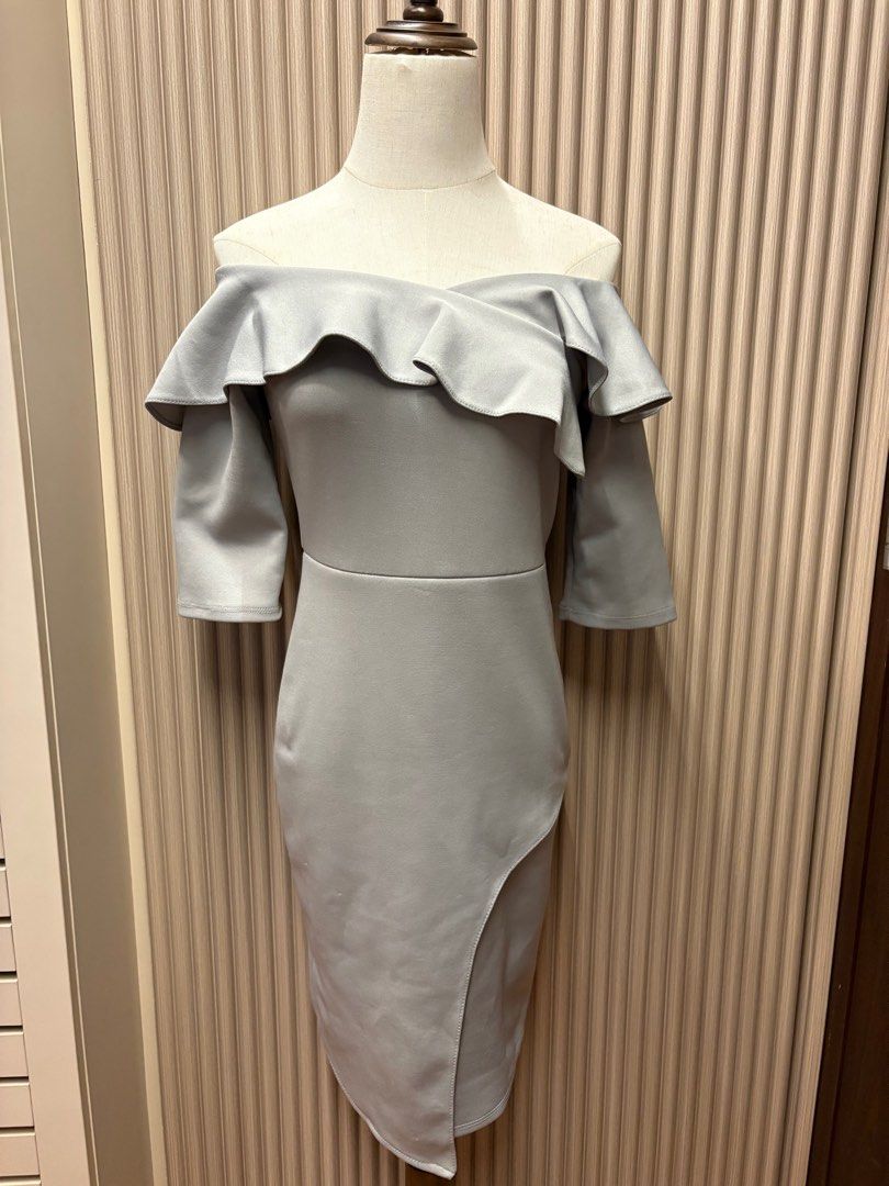 Celest Gray Off-Shoulder Dress (Category: Dresses) located in Mandaluyong City. Submitted by taraparador (Listing ID 1409374857, Image 2). Description: - Rarely used - during weddings - In good condition Elegant off-shoulder dress in a soft gray color. Features a flattering silhouette with a fitted bodice and a knee-length skirt with a side slit. The dress has short sleeves and a ruffled neckline. The back has a zipper closure..