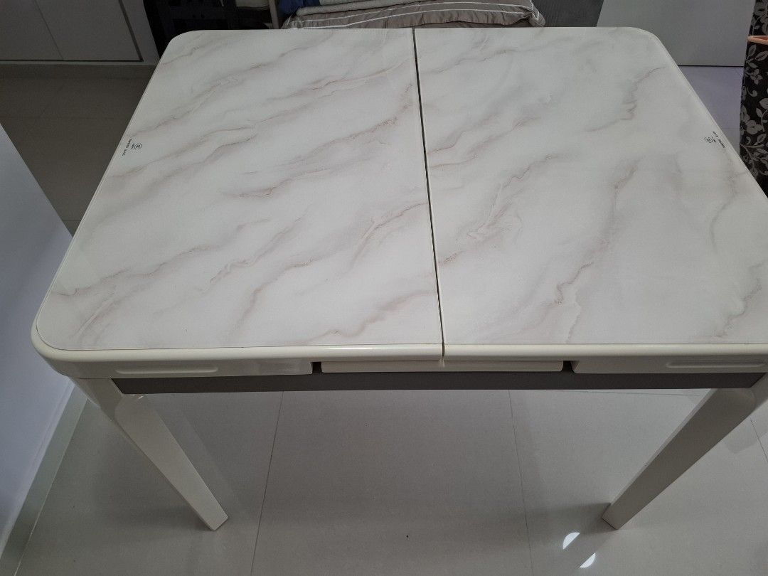Extendable Dining Table (Category: Tables & Sets) located in Singapore. Submitted by illyakuryakin (Listing ID 1409304814, Image 2). Description: - Extendable dining table - Elegant marble-look surface - Modern white frame - Extends to fit more guests - Ideal for small or large gatherings - 80cm x 100cm - 80cm x 130cm when extended - self collect.