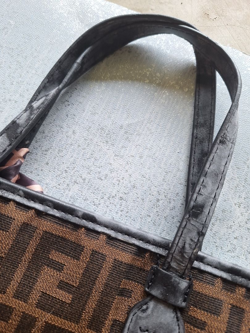 Fendi Tote Bag with Scarf and Strap (Category: Luxury Bags & Wallets) located in Malaybalay. Submitted by mags_sofia (Listing ID 1409381360, Image 2). Description: Dimensions: 14" × 4" × 9.5" Material: - gold brass tone hardware - clothed exterior and interior - has black leather accent for edges, handles, and brand tag - detachable strap and a scarf - top handle and a zipper closure. Compartment: - main compartment has 1 slot pockets and 1 zippe