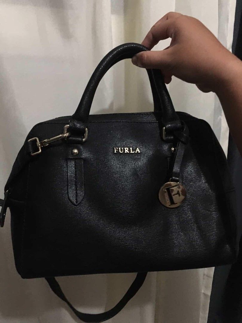 Furla 2 Way Bag (Category: Luxury Bags & Wallets) located in Agdangan. Submitted by sha.lane (Listing ID 1409379598, Image 2). Description: see pics for details, size, & flaws Hand bag / sling / office bag - Colour: Onyx - Saffiano Calf Leather - Furla Lettering Logo - Double Top Handle Leather Straps - 2 way, With Adjustable Longer Leather Shoulder Strap - Top Zip Closure - 1 Interior Zip Pocket; 2 Multifunctional Slip Pocket - Signature Fabric 