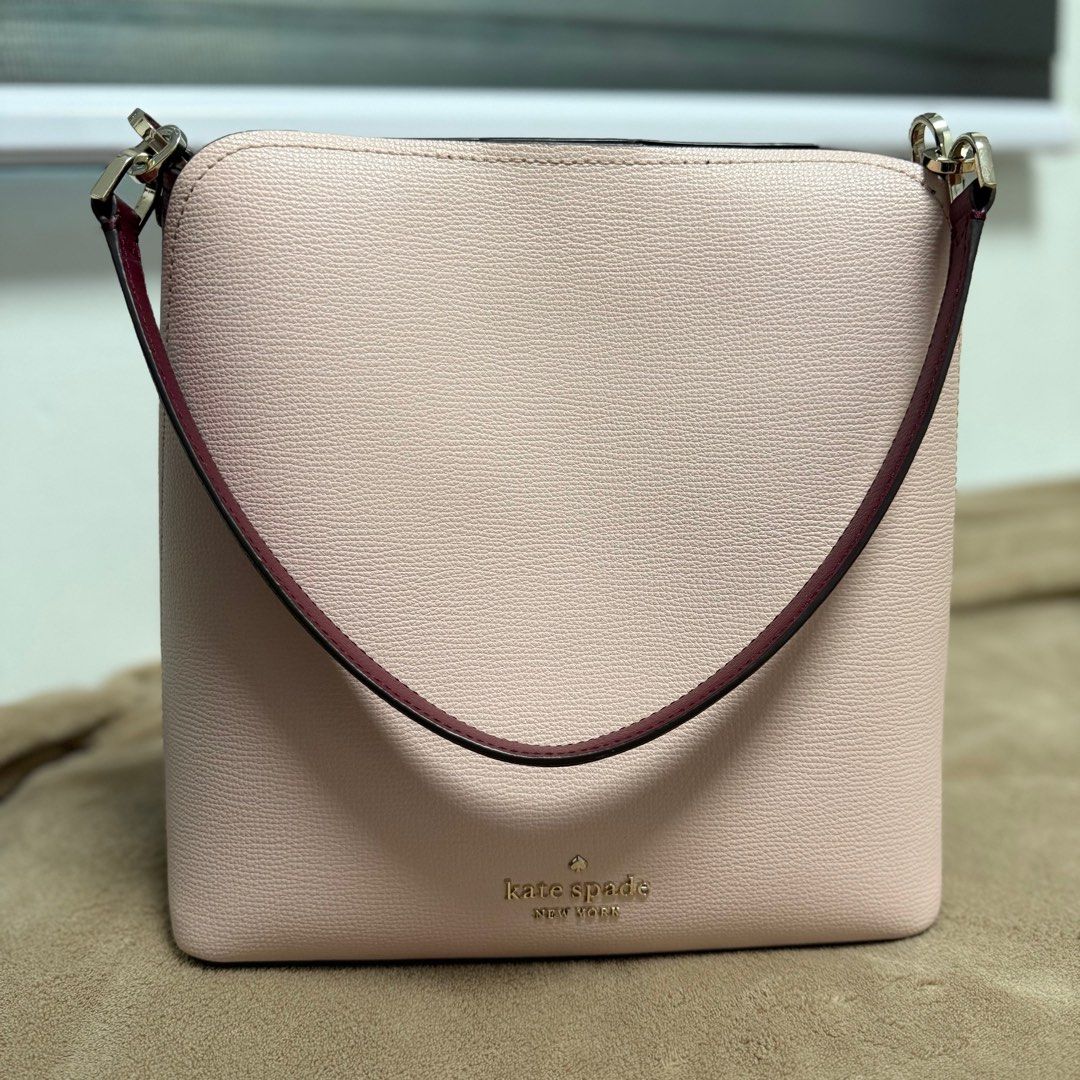Kate Spade Darcy Bucket Bag (Category: Luxury Bags & Wallets) located in Caloocan City. Submitted by madz_stuff (Listing ID 1409262853, Image 3). Description: - Size: 19.5cm L x 20cm H x 10.5cm W - Weight: 0.5kg - Handle drop: 6” - Strap drop: 19” - Material: Refined grain leather - Metal pinmount logo - Burgundy trim and strap - Detachable shoulder strap - Burgundy interior with small pocket - Magnetic snap closure - Exterior back slip pocket - 