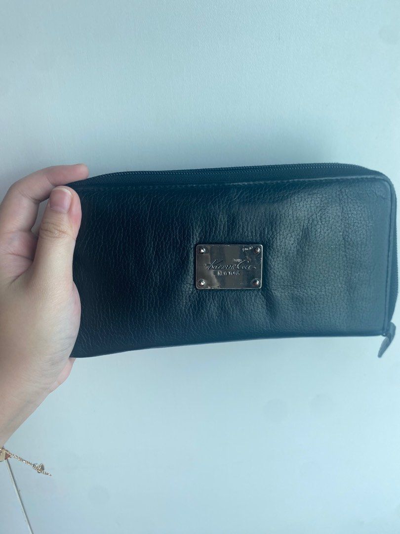 Kenneth Cole New York Black Wallet (Category: Wallets & Card holders) located in Pasig City. Submitted by angelaaaj (Listing ID 1409313756, Image 1). Description: - Black Kenneth Cole New York wallet - Zip-around closure - Multiple interior compartments for cards and cash - Zippered coin pocket - Silver-toned brand plate - Light grey interior.