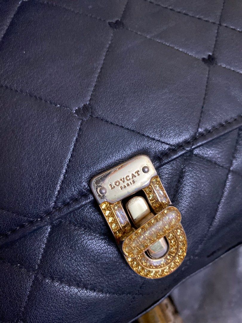 LOVCAT Paris Black Quilted Shoulder Bag (Category: Luxury Bags & Wallets) located in Cavite. Submitted by rmquin05 (Listing ID 1409394854, Image 2). Description: - LOVCAT Paris shoulder bag - Black quilted design - Gold-tone clasp with embellishments - Chain straps - Black lining - Interior zippered pocket - LOVCAT label - Gold-tone hardware - Flap closure.