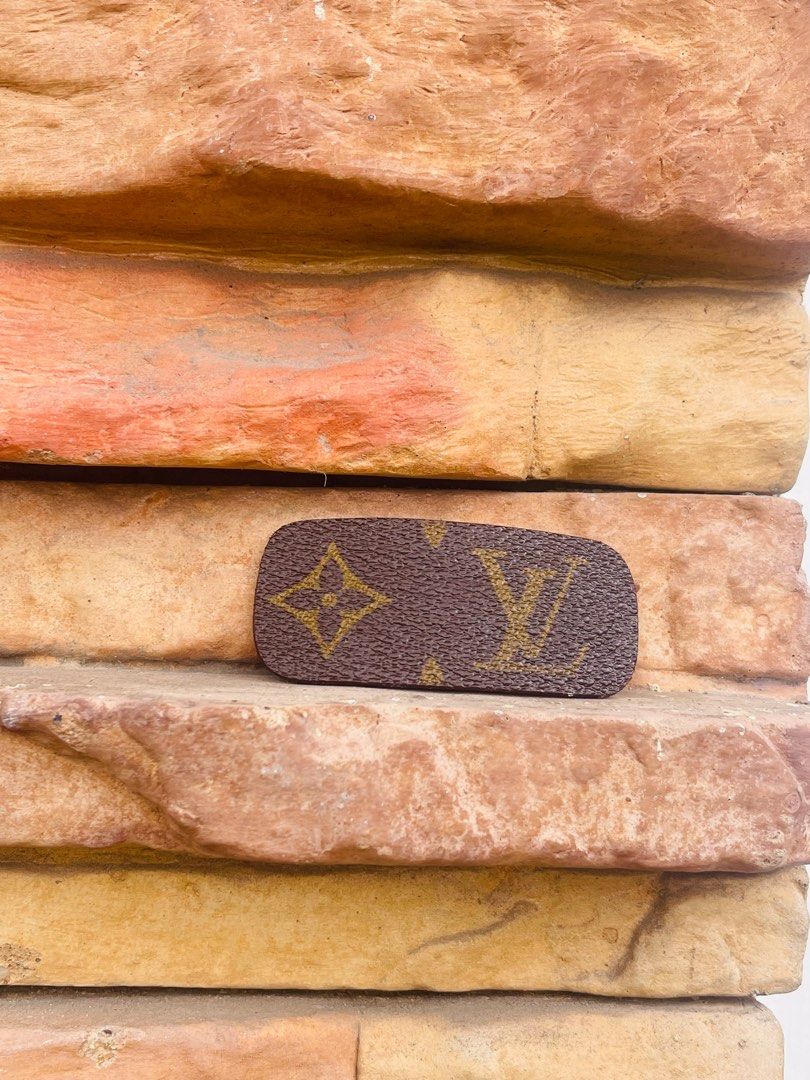 Repurposed Louis Vuitton Hair Clip (Category: Hair Accessories) located in Cavite. Submitted by authenticfindsbyging (Listing ID 1409434698, Image 2). Description: - Repurpose Louis Vuitton Monogram Hair Clip - Classic LV logo in gold on a brown background - Brown leather backing - Silver-tone metal clasp - Suitable for all hair types - Adds a touch of luxury to any hairstyle.