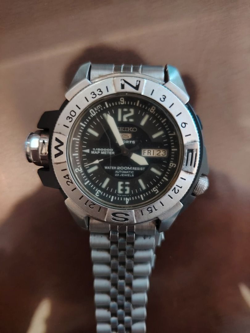 Seiko 5 Sports Map Meter Watch (Category: Men's Watches) located in Cavite. Submitted by blackrain4 (Listing ID 1409322634, Image 3). Description: - Seiko 5 Sports watch - Black dial with day and date display - Rotating bezel with compass markings - Stainless steel bracelet - Water-resistant - Map meter function - Unique design with prominent crown guard.