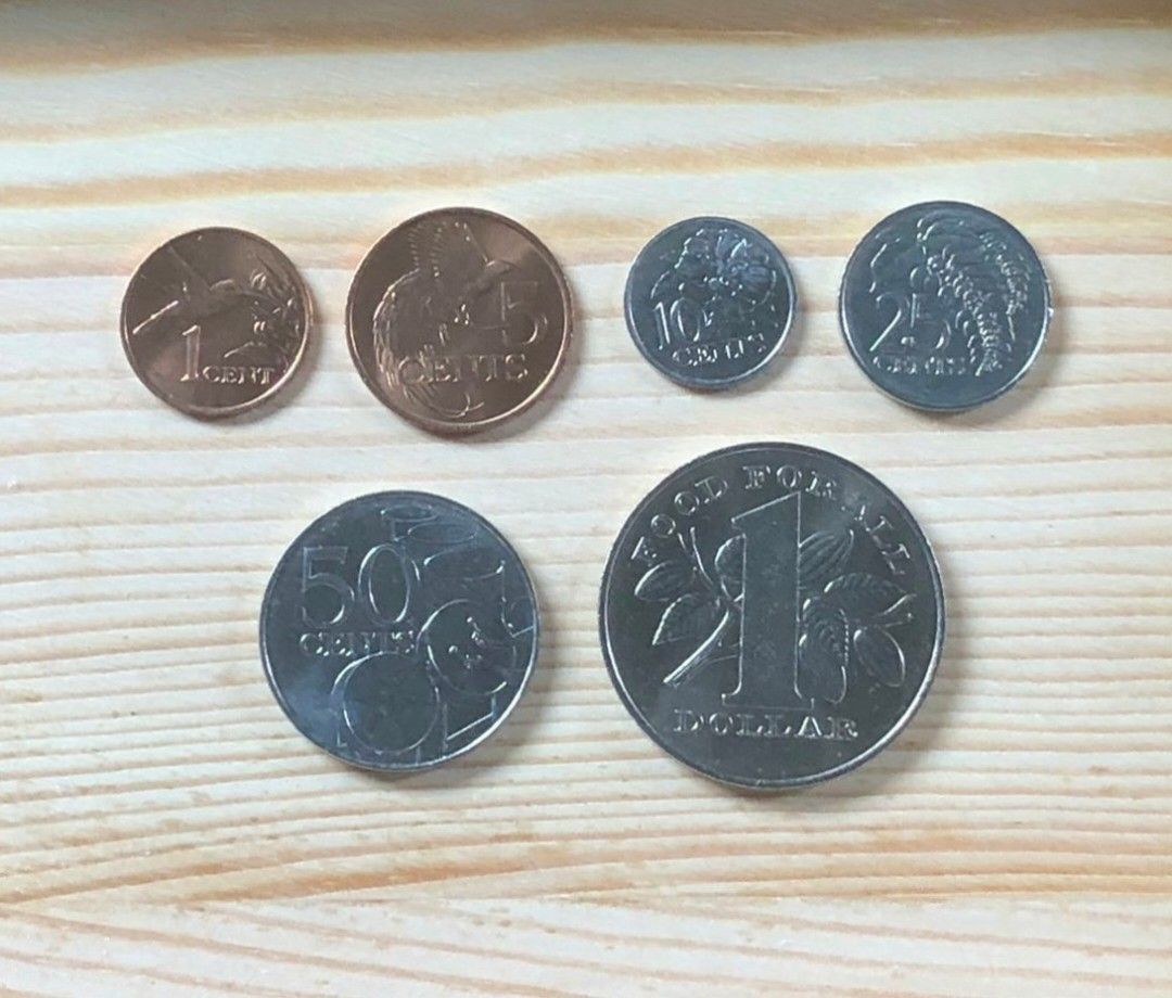 Trinidad and Tobago Coin Set (Category: Currency) located in Marikina City. Submitted by kazmooth58 (Listing ID 1409396520, Image 1). Description: Collection of Trinidad and Tobago coins. Includes 1 cent (1994), 5 cents (1992), 10 cents (1990), 25 cents (1983), 50 cents (1979), and 1 dollar (1979) coins. The coins feature various designs, including a hummingbird, a bird, flowers, and drums. The reverse sides display the coat of arms of Trinidad a