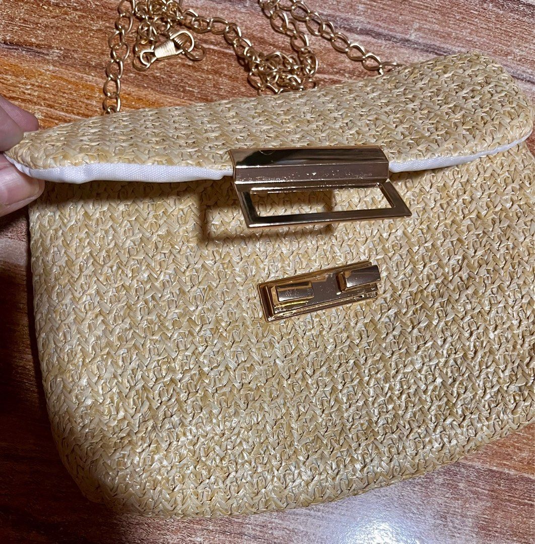 Woven Straw Shoulder Bag with Gold Chain (Category: Shoulder Bags) located in Makati City. Submitted by mamugh (Listing ID 1409286262, Image 2). Description: - Woven straw shoulder bag - Elegant gold chain strap - Rectangular shape - Secure flap closure with gold-tone clasp - Lined with white fabric - Ideal for carrying essentials - Adds a touch of elegance.