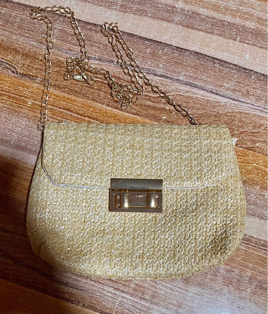 Woven Straw Shoulder Bag with Gold Chain (Category: Shoulder Bags) located in Makati City. Submitted by mamugh (Listing ID 1409286262, Image 1). Description: - Woven straw shoulder bag - Elegant gold chain strap - Rectangular shape - Secure flap closure with gold-tone clasp - Lined with white fabric - Ideal for carrying essentials - Adds a touch of elegance.