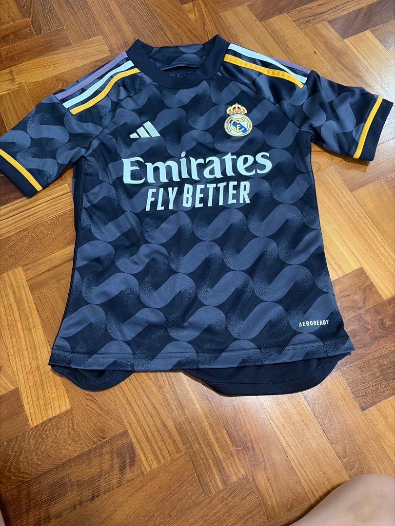 Adidas Real Madrid 2022/23 Third Jersey (Category: Babies & Kids Fashion) located in Singapore. Submitted by graceneo8024 (Listing ID 1409442817, Image 1). Description: - Official Adidas Real Madrid third jersey from the 2022/23 season. - Features the Emirates Fly Better sponsor logo. - Unique wave pattern design. - "REAL MADRID" printed on the back..