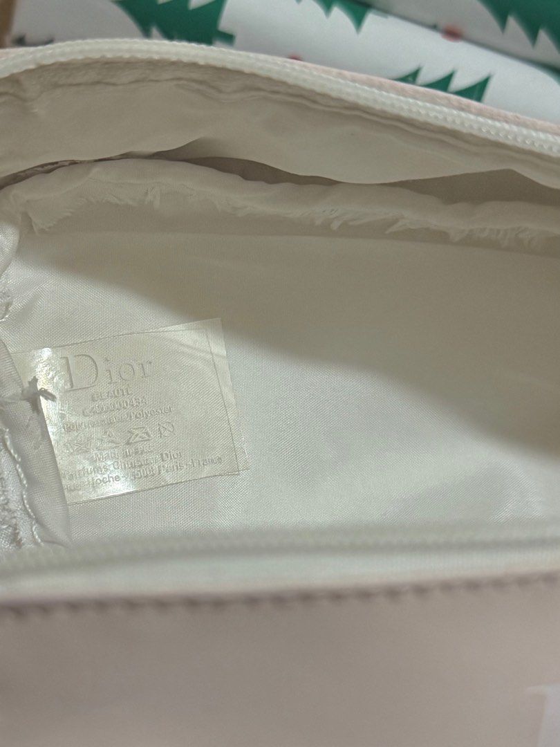 AUTHENTIC Dior Pink Cosmetic Pouch (VIP Gift) (Category: Luxury Bags & Wallets) located in Quezon City. Submitted by naptimeph (Listing ID 1409481930, Image 3). Description: - Authentic Dior cosmetic pouch - Soft pink color - Zipper closure - Adorned with a star-shaped charm - White interior lining with Dior label - Compact size, perfect for makeup or small essentials -spacious Issue: see the last 2 photos (chipped paint sa zipper & may small sta