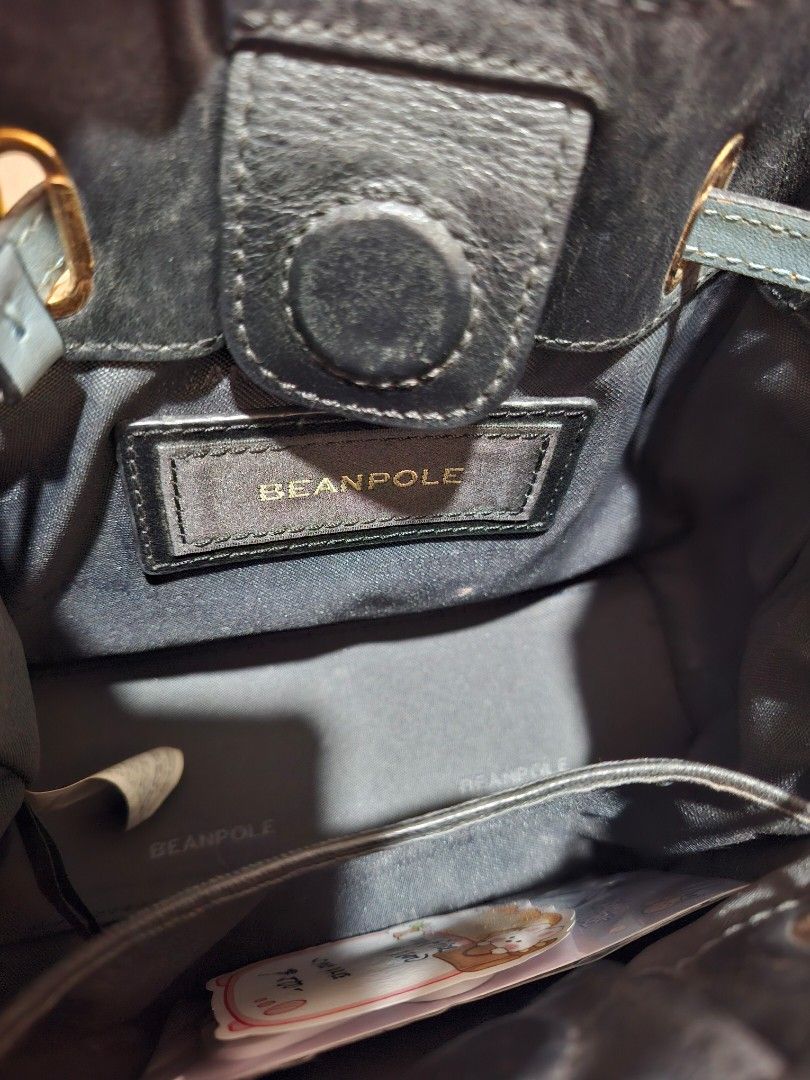 BEANPOLE Blue Handbag with Gold Hardware [ORIGINAL] (Category: Luxury Bags & Wallets) located in Rizal. Submitted by she_prelovedbagsfromkorea (Listing ID 1409544296, Image 3). Description: - Beanpole blue handbag - Gold hardware - Detachable shoulder strap - Drawstring closure - Small interior pocket - Signs of wear on corners and edges - Includes gold chain strap - Includes two short handles.