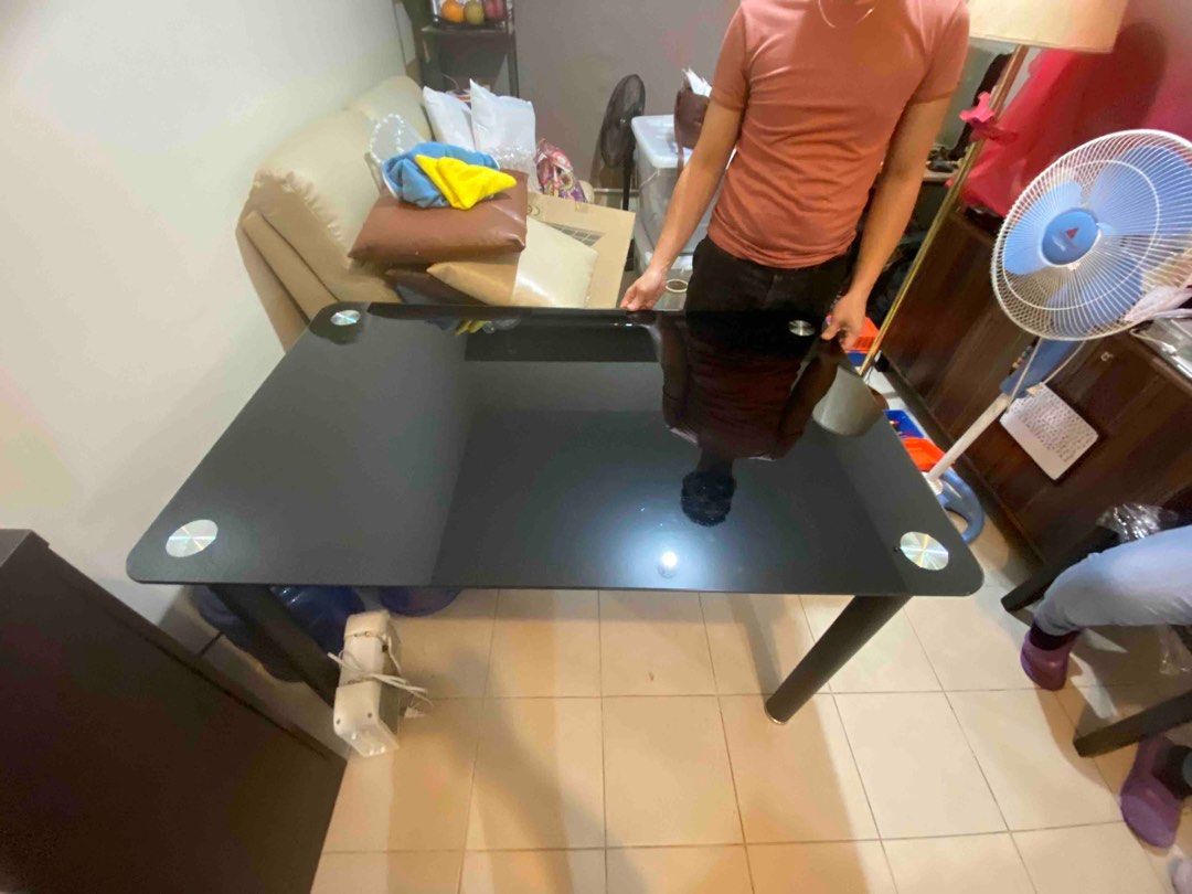 Black Glass Top Table (Category: Tables & Sets) located in Makati City. Submitted by mysticfox-710a (Listing ID 1409586946, Image 1). Description: Black glass top table with silver accents. Rectangular shape with rounded corners. Modern design. Perfect for modern living or dining 30.5in width, 48in length, 30in height .
