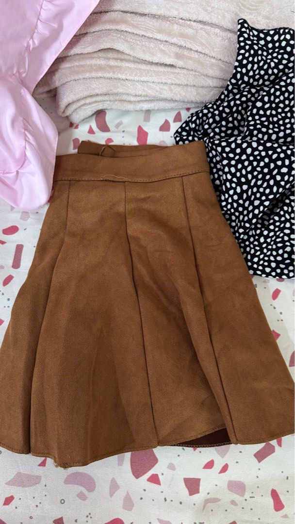 Brown Pleated Mini Skirt (Category: Skirts) located in Quezon City. Submitted by declutterrringme (Listing ID 1409498809, Image 2). Description: - Brown pleated mini skirt - High-waisted - Classic A-line silhouette - Suede or suede-like material - Great for casual or dressed-up outfits - Pairs well with different tops and shoes.