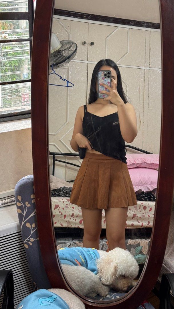 Brown Pleated Mini Skirt (Category: Skirts) located in Quezon City. Submitted by declutterrringme (Listing ID 1409498809, Image 1). Description: - Brown pleated mini skirt - High-waisted - Classic A-line silhouette - Suede or suede-like material - Great for casual or dressed-up outfits - Pairs well with different tops and shoes.