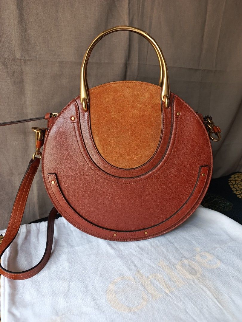 Chloe Pixie Round Bag (Category: Luxury Bags & Wallets) located in Bulacan. Submitted by zhetty_declutter (Listing ID 1409463649, Image 2). Description: - Chloe Pixie Bag - Brown leather exterior with suede panel - Unique round shape - Top handle and detachable shoulder strap - Interior zipped pocket - Gold-tone hardware - Chloe logo detail - Includes dust bag.