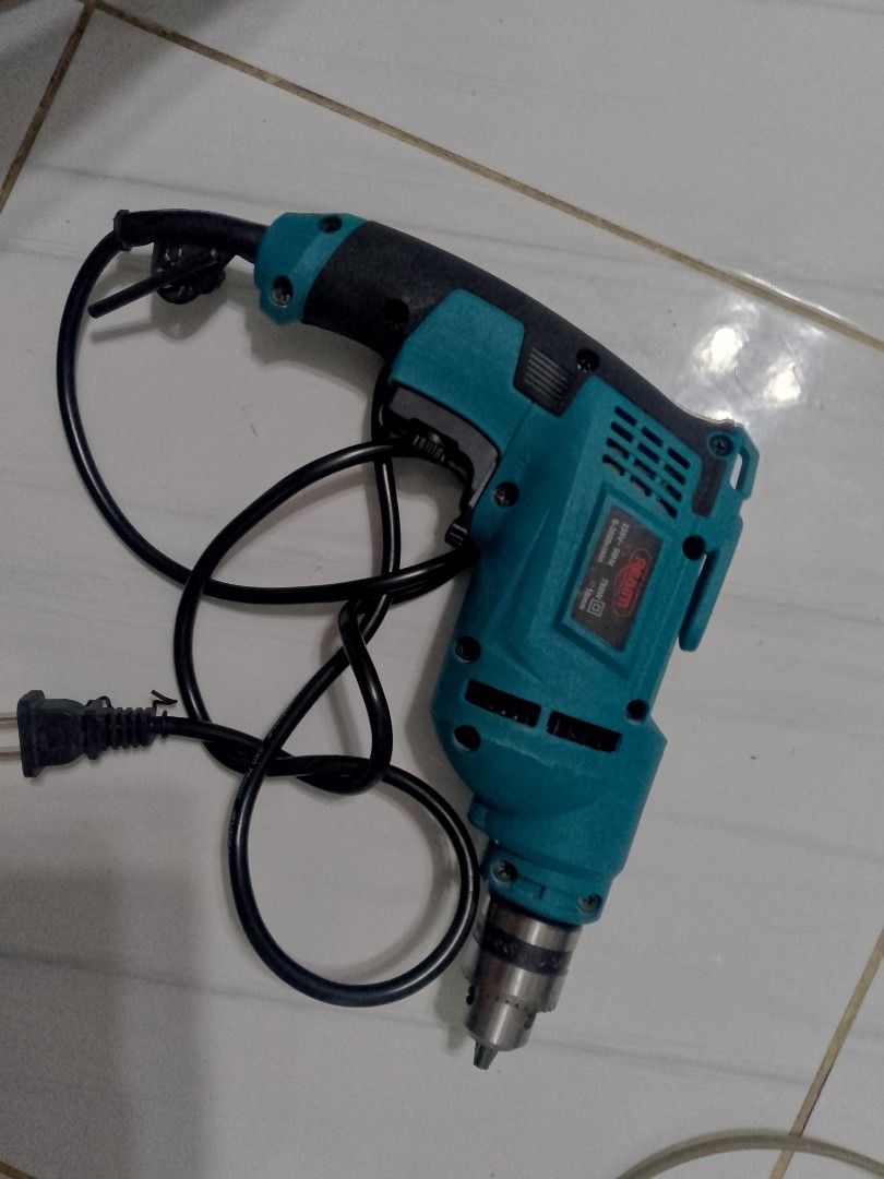 Electric Drill (Category: Construction Tools & Equipment) located in Manila. Submitted by cj1808 (Listing ID 1409510252, Image 1). Description: - Teal and black electric drill - Includes power cord - In good working condition - Standard three-prong plug - Suitable for various drilling tasks.