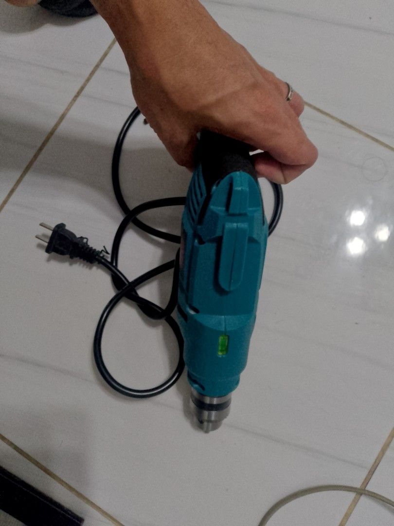 Electric Drill (Category: Construction Tools & Equipment) located in Manila. Submitted by cj1808 (Listing ID 1409510252, Image 3). Description: - Teal and black electric drill - Includes power cord - In good working condition - Standard three-prong plug - Suitable for various drilling tasks.