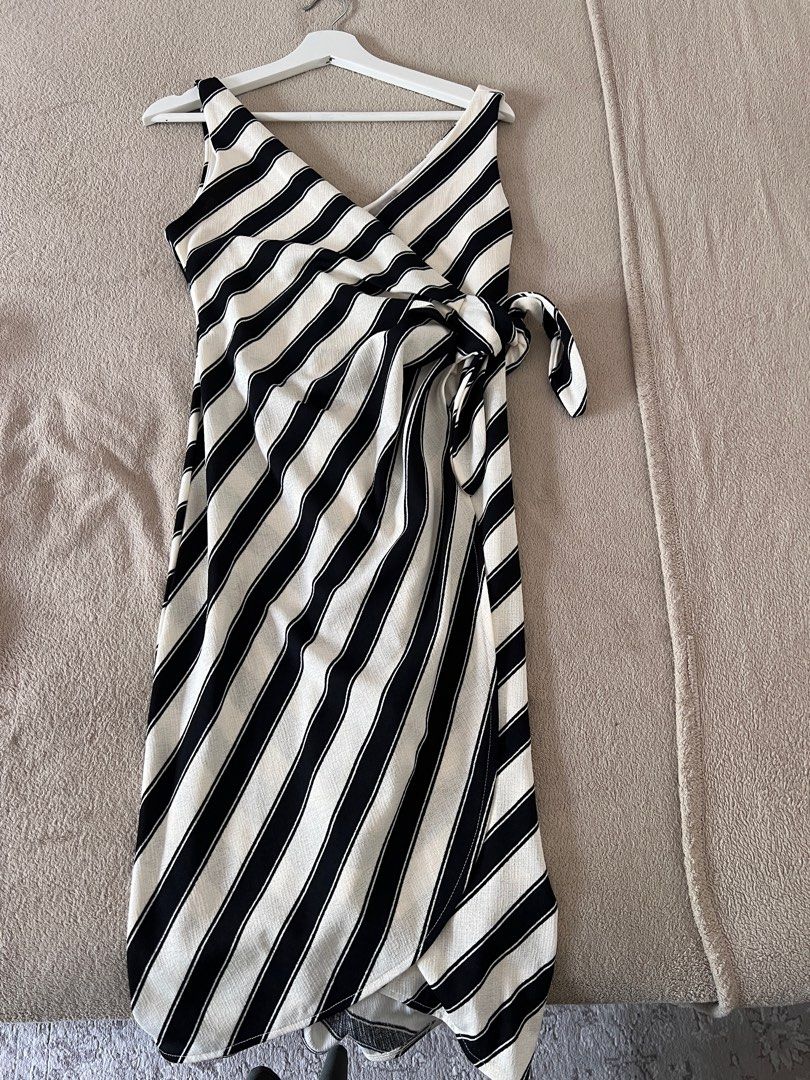 H&M Striped Wrap Dress - Size S (Category: Dresses) located in Muntinlupa City. Submitted by psm.seconds (Listing ID 1409458578, Image 1). Description: - H&M wrap dress - Black and white striped pattern - Size: S - Features a V-neck - Sleeveless design - Tie closure at the waist - Made of lightweight fabric.