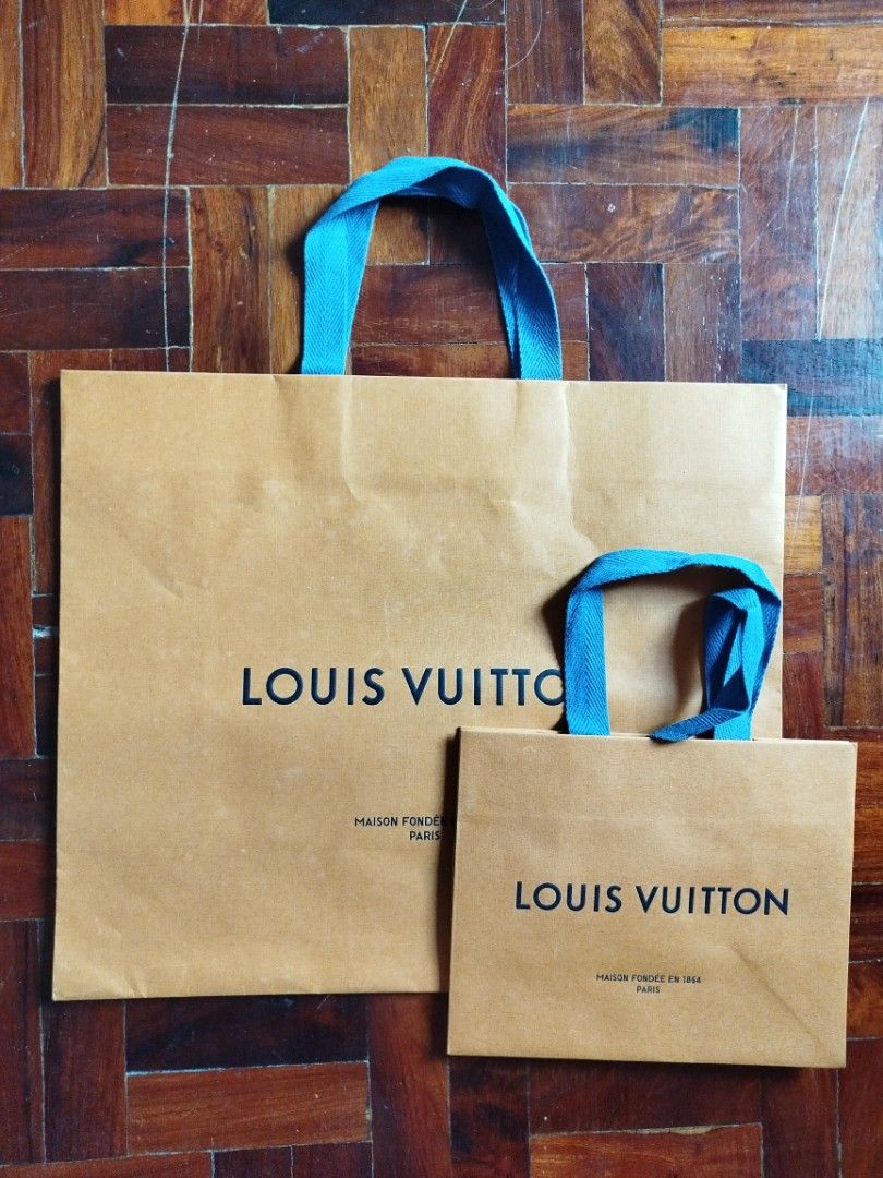 Louis Vuitton Paper Bags (Category: Luxury Bags & Wallets) located in Caloocan City. Submitted by edlan_23 (Listing ID 1409505730, Image 1). Description: - Authentic Louis Vuitton paper bags - Includes two bags: one large, one small - Features the iconic Louis Vuitton embossed logo - Stylish blue handles - Made of durable brown paper - Perfect for gifting or collecting.
