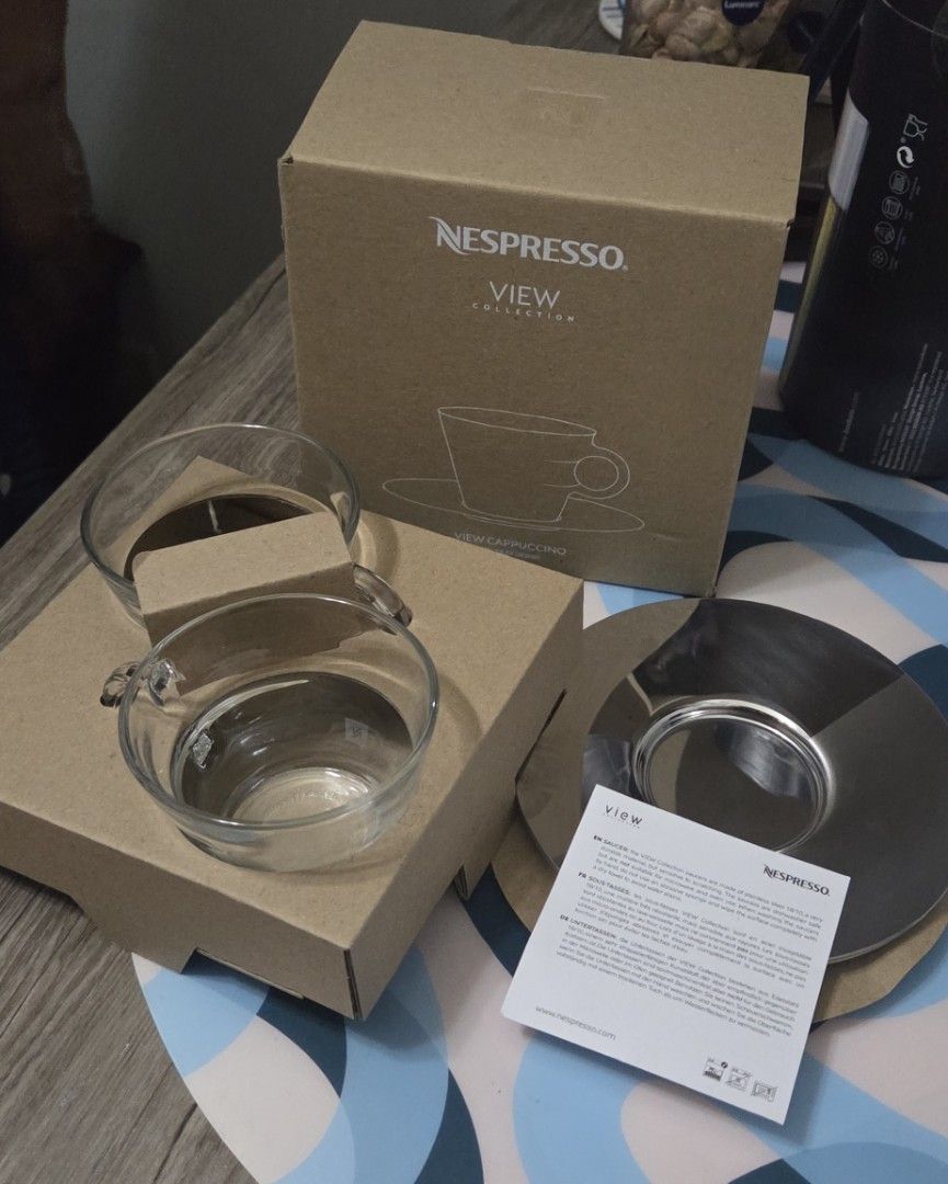 Nespresso View Cappuccino Cup Set (Category: Coffee & Tea Tableware) located in Manila. Submitted by sterling_grace (Listing ID 1409444614, Image 2). Description: - Nespresso View Collection set - Includes two glass coffee cups - Features metallic saucers - Cups have handles - Comes with original box and packaging - Includes original documentation.