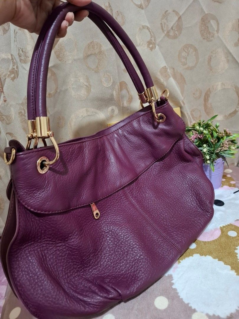 SISLEY Handbag - Purple [ORIGINAL] (Category: Luxury Bags & Wallets) located in Rizal. Submitted by she_prelovedbagsfromkorea (Listing ID 1409540831, Image 2). Description: - Authentic Sisley handbag - Stunning purple color - Elegant gold-tone hardware - Versatile top handle and detachable shoulder strap - Convenient interior zip pocket - Includes a stylish Sisley charm - Luxurious textured finish - Secure gold zipper - Interior lined with a patt