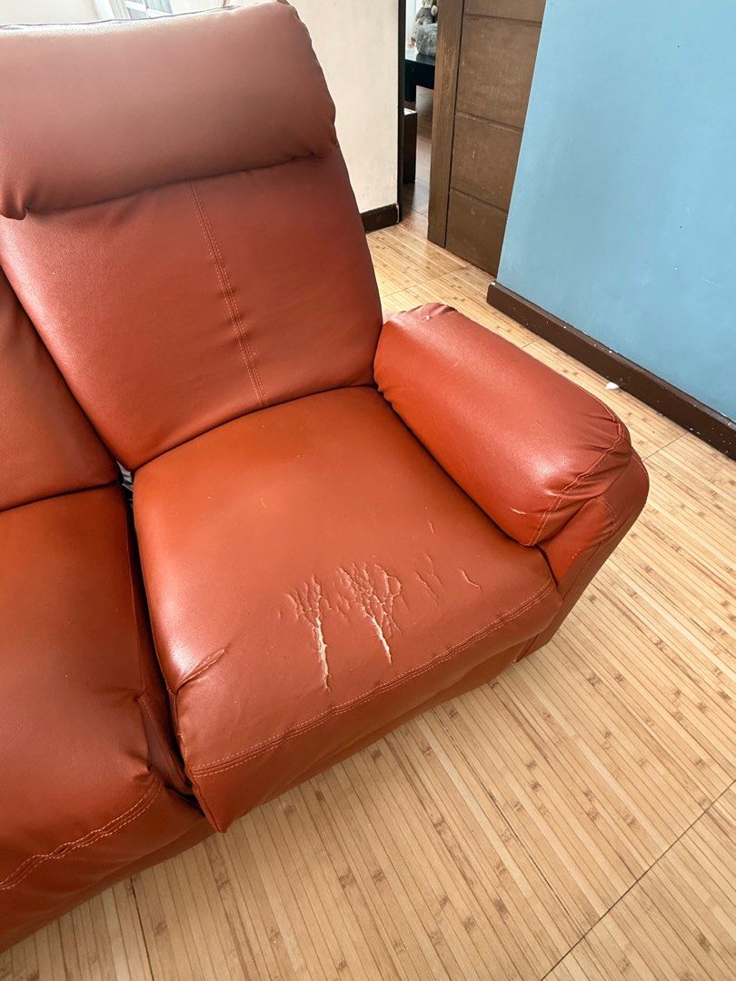 Tan Brown Reclining Sofa (Category: Sofas) located in Pasig City. Submitted by theorchidgirl (Listing ID 1409461026, Image 3). Description: - Two-seater brown reclining sofa - Features two individual reclining seats - Made of faux leather - Shows visible wear and tear (peeling on one seat cushion) - Includes armrests and headrest - Ideal for living room use.