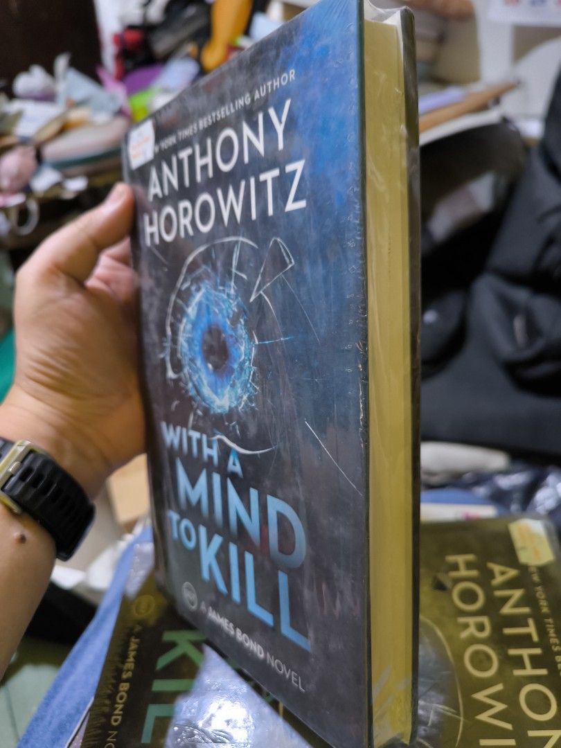 With a Mind to Kill - James Bond Novel by Anthony Horowitz (Category: Storybooks) located in Manila. Submitted by fredrk (Listing ID 1409461761, Image 3). Description: James Bond novel "With a Mind to Kill" by Anthony Horowitz. The book is still in its original packaging. The cover features a shattered glass effect with a blue center. The back of the book includes quotes from The Guardian, The Scotsman, Daily Express, and The Times. Reduced price