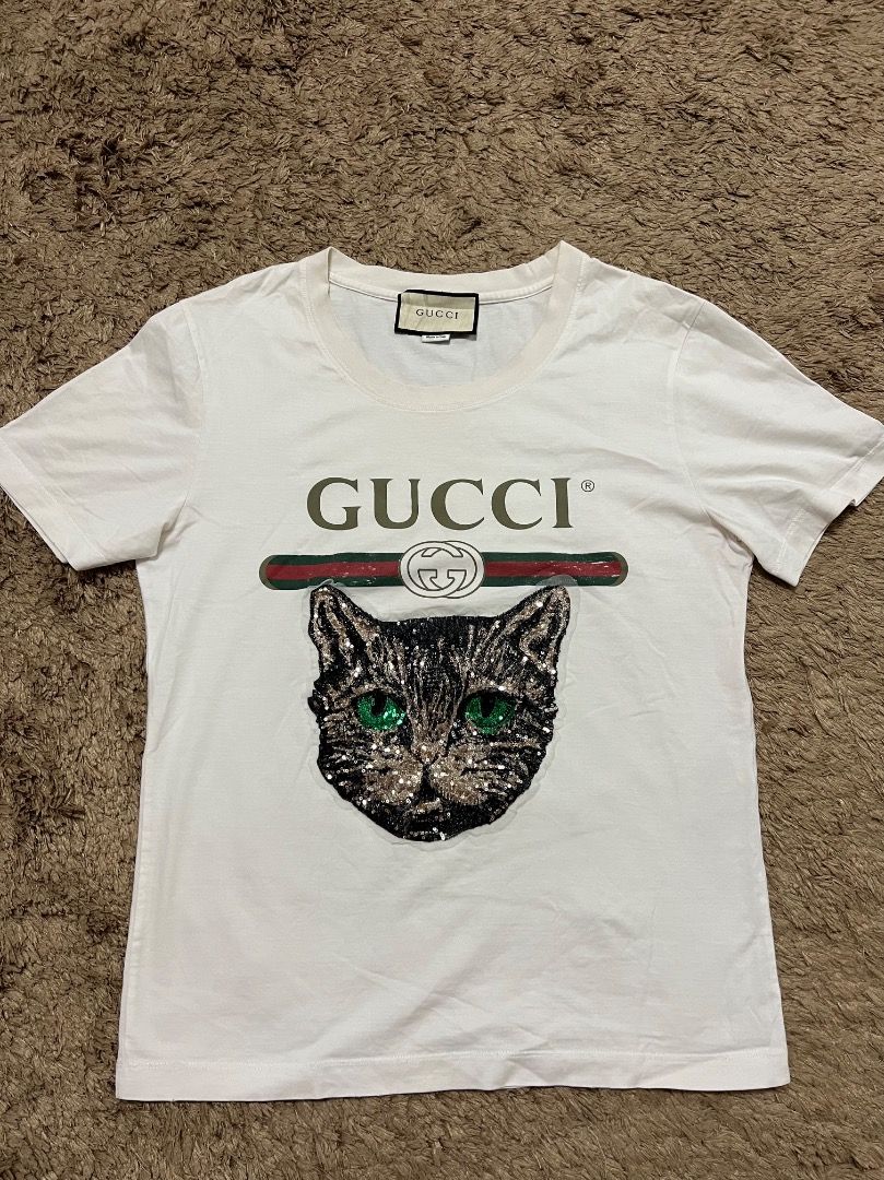 Authentic GUCCI shirt (Category: Luxury Apparel) located in Manila. Submitted by cluttercrushers (Listing ID 1409686245, Image 1). Description: White Gucci logo T-shirt with a sequined Mystic Cat appliqué Rare to find. What you see is what you get. Payment first before shipment. .