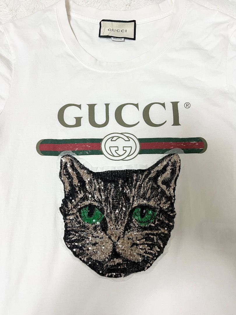 Authentic GUCCI shirt (Category: Luxury Apparel) located in Manila. Submitted by cluttercrushers (Listing ID 1409686245, Image 3). Description: White Gucci logo T-shirt with a sequined Mystic Cat appliqué Rare to find. What you see is what you get. Payment first before shipment. .