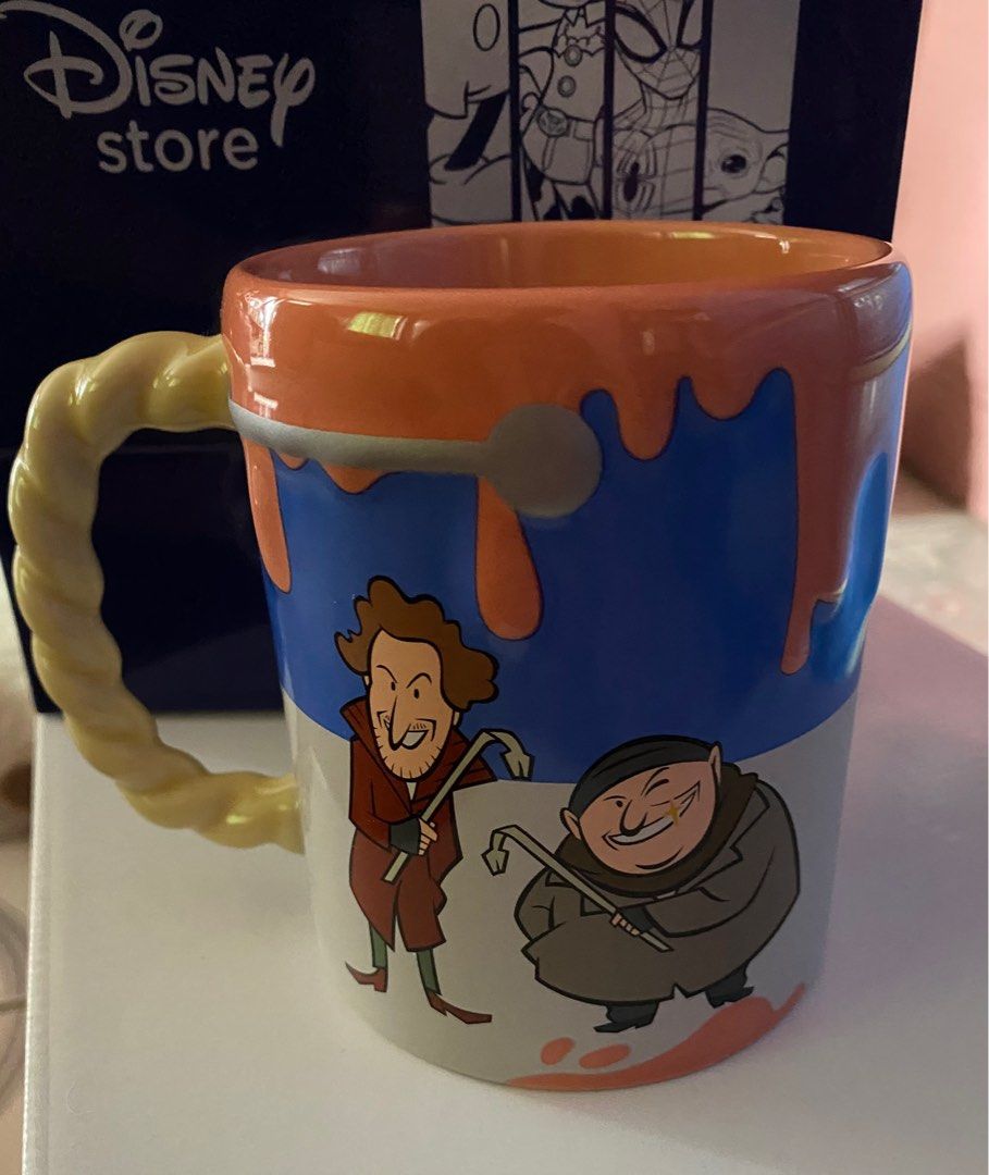 Disney Home Alone Mug (Category: Coffee & Tea Tableware) located in Pasig City. Submitted by bartbuy (Listing ID 1409625056, Image 1). Description: - Home Alone themed mug - Features characters and quotes from the movie - Unique twisted handle - Colorful design - From the Disney Store - Price: P1,149.00 -Height: 4 Inches .