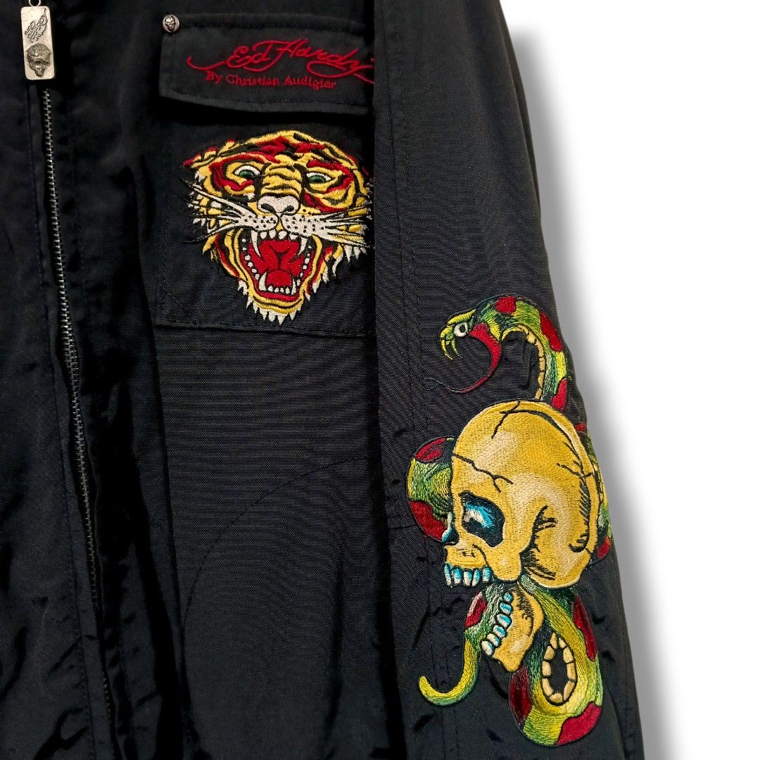 Ed Hardy Embroidered Jacket (Black & Red) (Category: Coats, Jackets and Outerwear) located in Manila. Submitted by mf.classics (Listing ID 1409755488, Image 3). Description: - Ed Hardy embroidered jacket - Black exterior with gold and red accents - Designs: Tiger, skull, snake (front & sleeves), eagle (back) - Ed Hardy branding on back and interior - Red interior lining - Zipper closure - Multiple pockets - Measurements: 27 L 23 W.