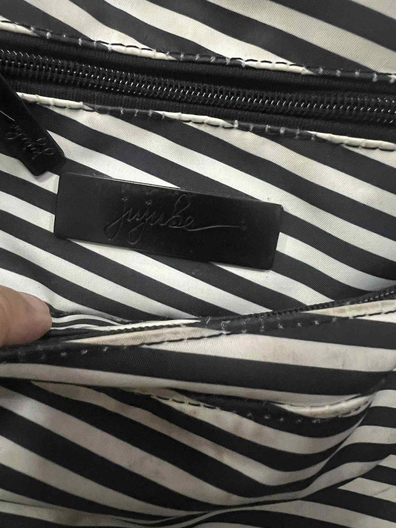 JuJuBe Black and White Stripe Diaper Bag (Category: Diaper Bags & Wetbags) located in Antipolo. Submitted by puzzleaddict (Listing ID 1409729955, Image 1). Description: - JuJuBe diaper bag - Black and white stripes - Multiple compartments and zippers - Front pocket - Striped interior - Black hardware - Top handle - Shows wear and discoloration on edges and zippers.