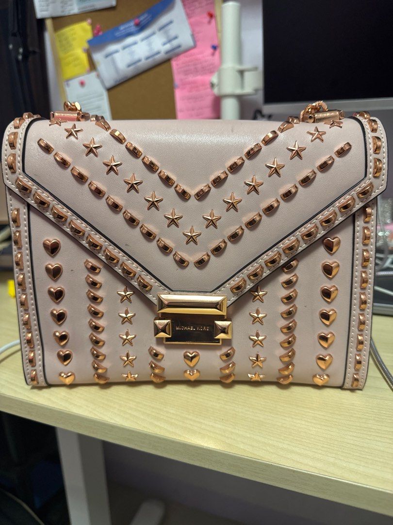 Michael Kors Studded Shoulder Bag (Category: Luxury Bags & Wallets) located in Manila. Submitted by franzescaaaa (Listing ID 1409729101, Image 1). Description: - Michael Kors shoulder bag - Blush pink exterior - Gold-tone star and heart studs - Chain strap - Flap closure with Michael Kors logo - Interior zippered pocket - Perfect for everyday use.